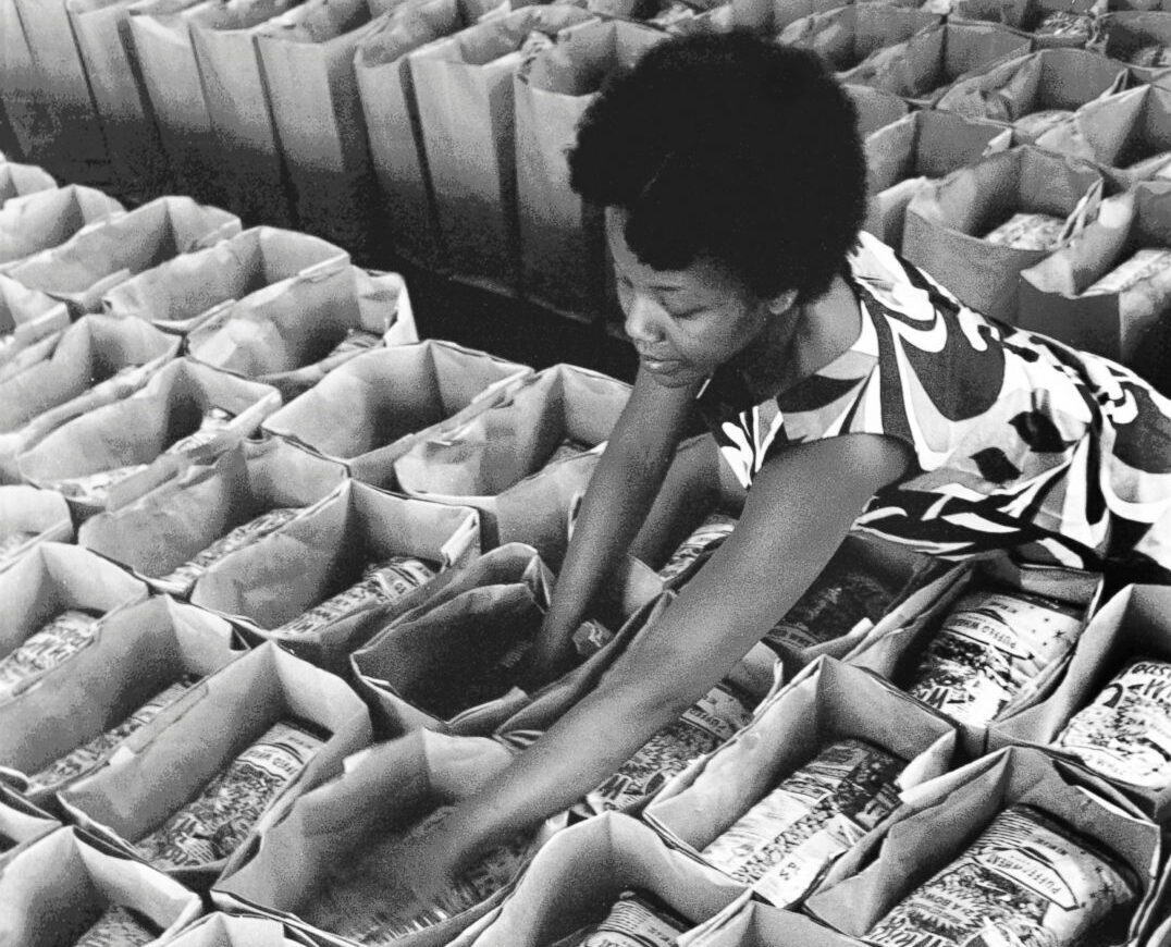 A Black Panther Party member prepares bags of food for distribution of the Panther Free Food Program at the Oakland Coliseum at the Black Panther Community Survival Conference, March 1972, in Oakland, California.