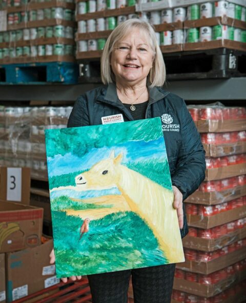 Food Bank Manager Kate holds artwork done by local Ukrainian girl