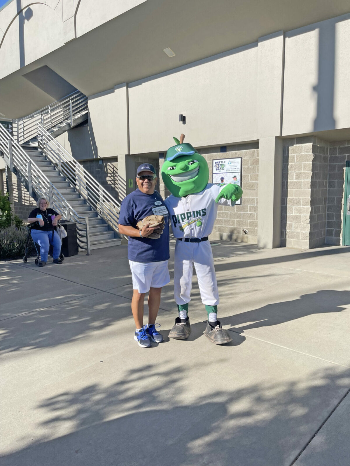 Northwest Harvest employee poses next to Pippins mascot